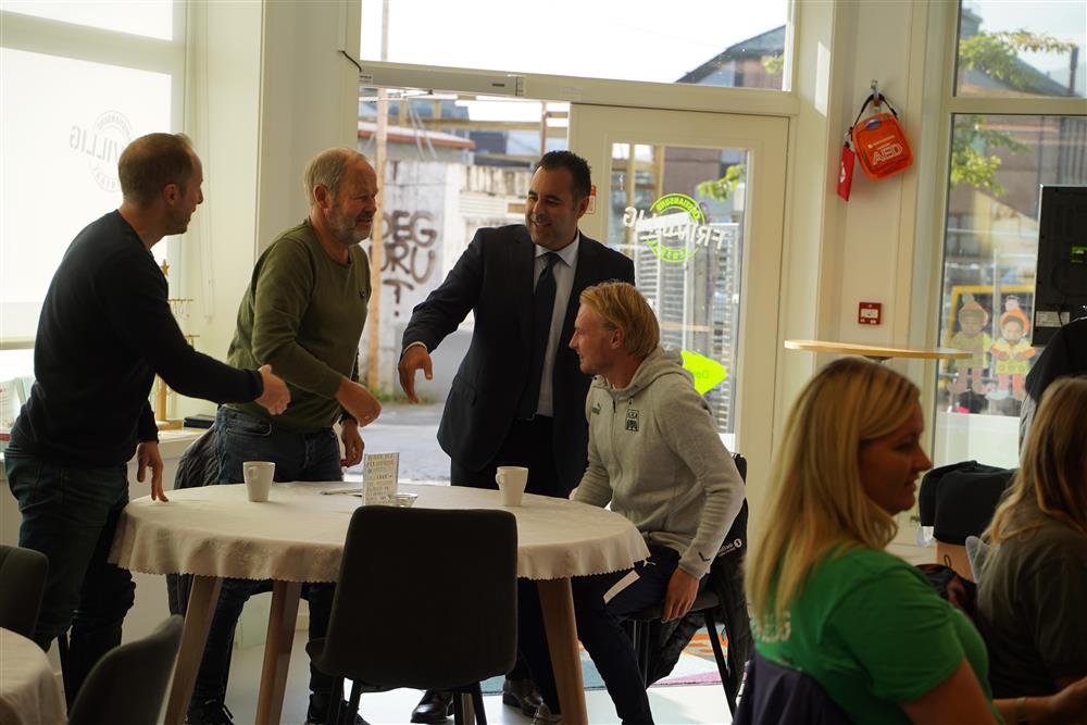 Stortingspresidenten hilser på tre menn ved et bord - Klikk for stort bilde