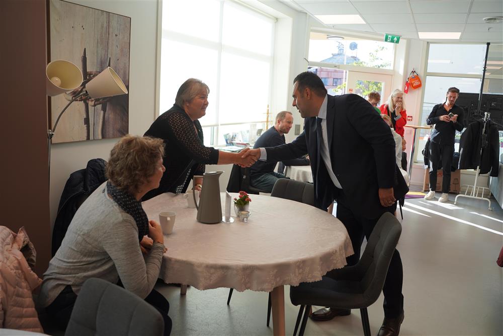 Stortingspresidenten hilser på to damer ved et bord - Klikk for stort bilde