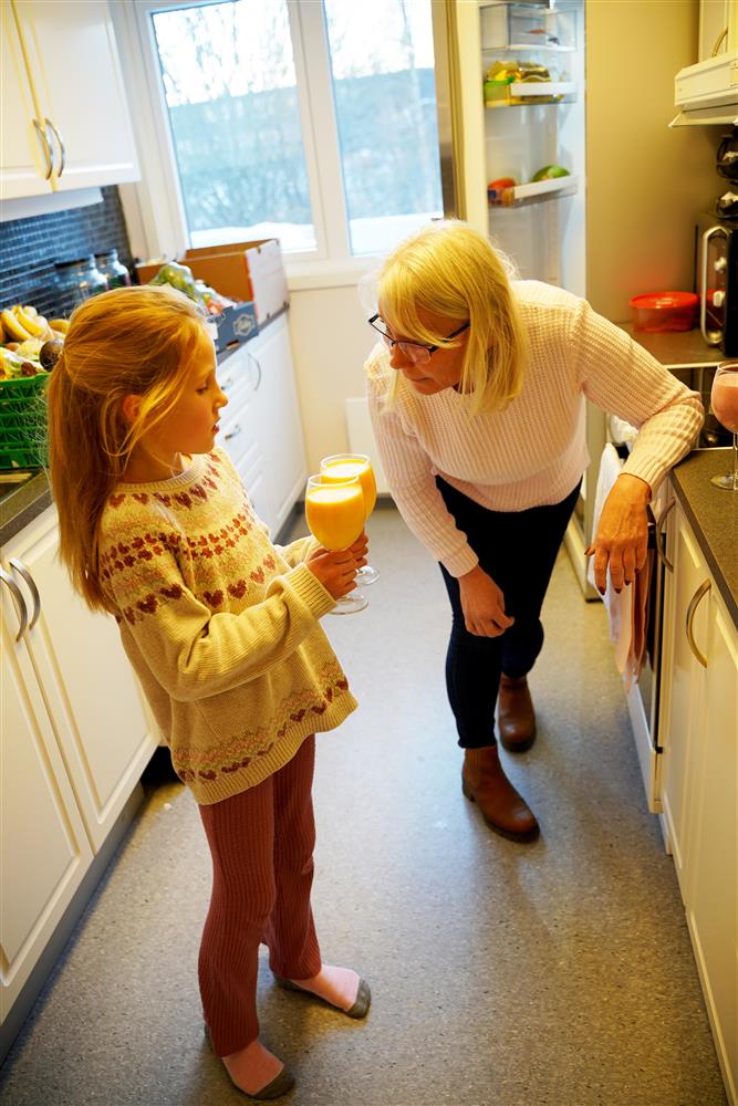 jente og dame på kjøkken med glass i hånden - Klikk for stort bilde