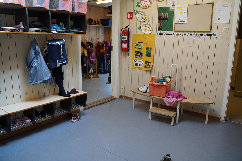 Bilde 2 av inngangsrom i barnehagen, en liten blå sekk henger fra en knagg - Klikk for stort bilde
