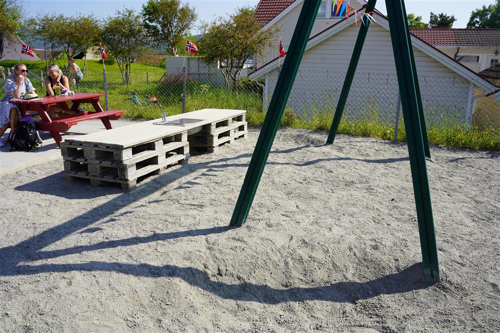 Bilde av sandkasse, disse og utevask på utearealet til barnehagen - Klikk for stort bilde